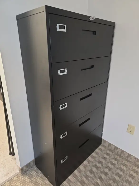 Five drawer metal filing cabinet assembled in an office