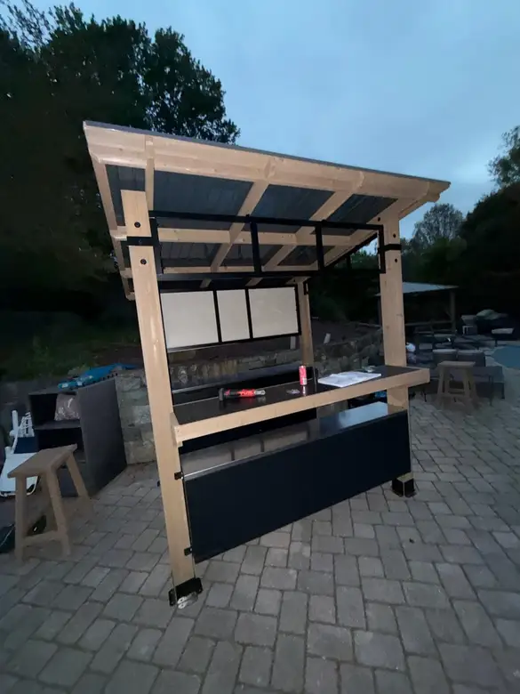 Timber outdoor shelving unit being assembled on a paver patio