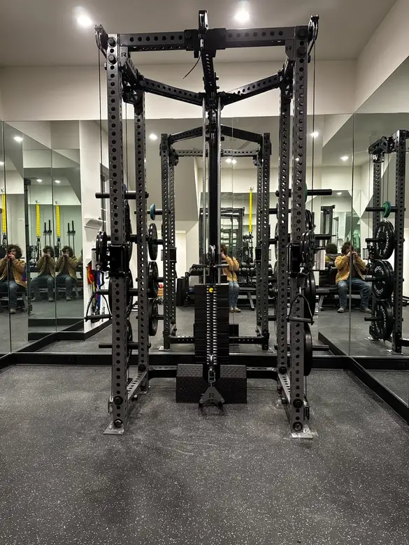 Power rack and barbell assembled in a mirrored home gym