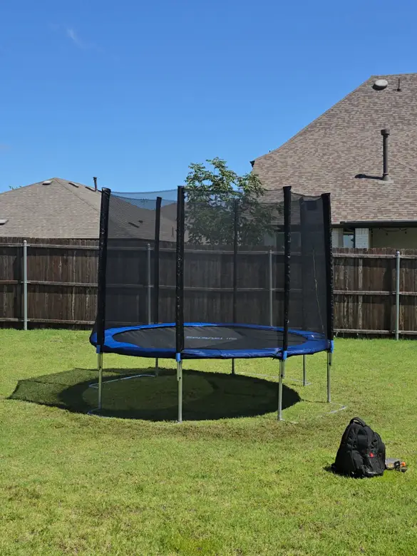 Round trampoline with a safety net assembled and levelled on a lawn
