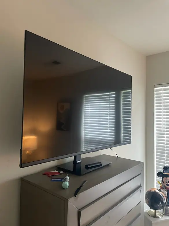 Large flat screen television set up above a media console